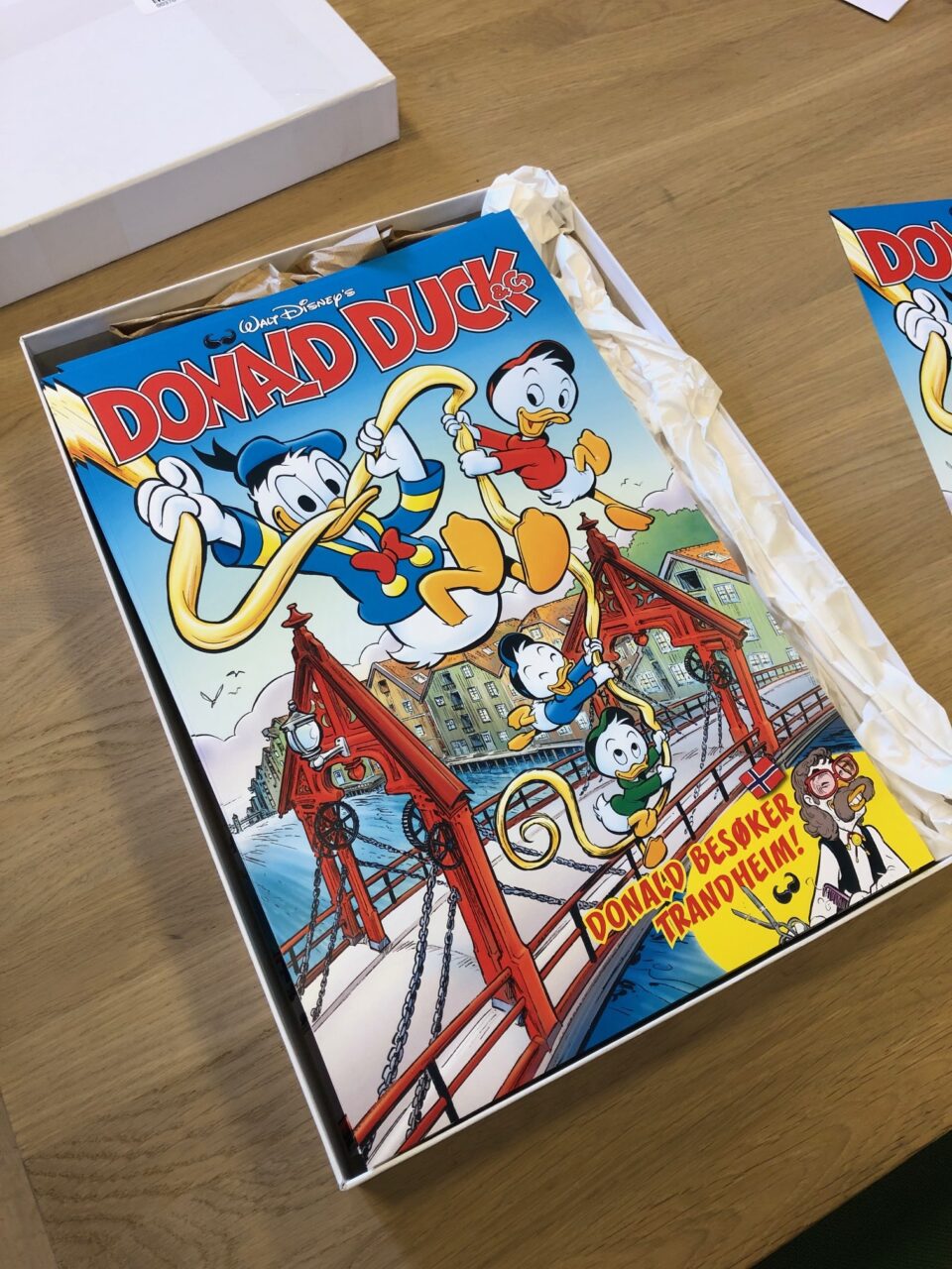 En kake med Donald Duck-tema med levende tegneserier, med Donald og andre karakterer, på et trebord.